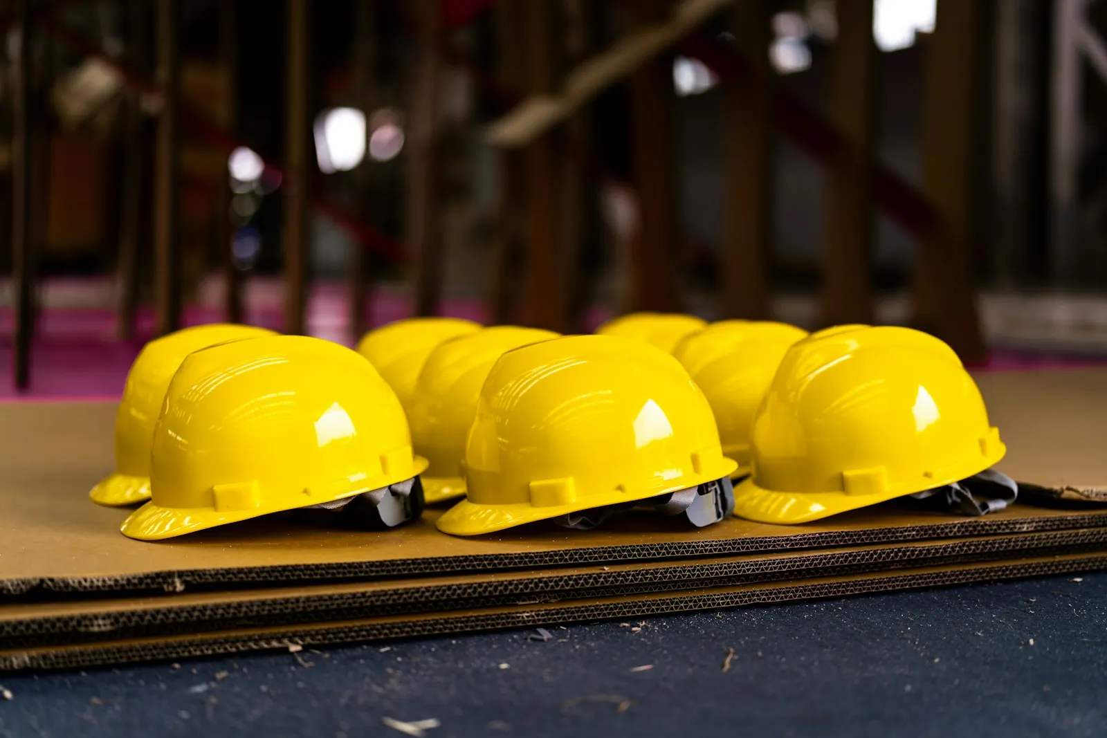 Schutzhelme liegen aufgereiht auf einer Baustelle bereit